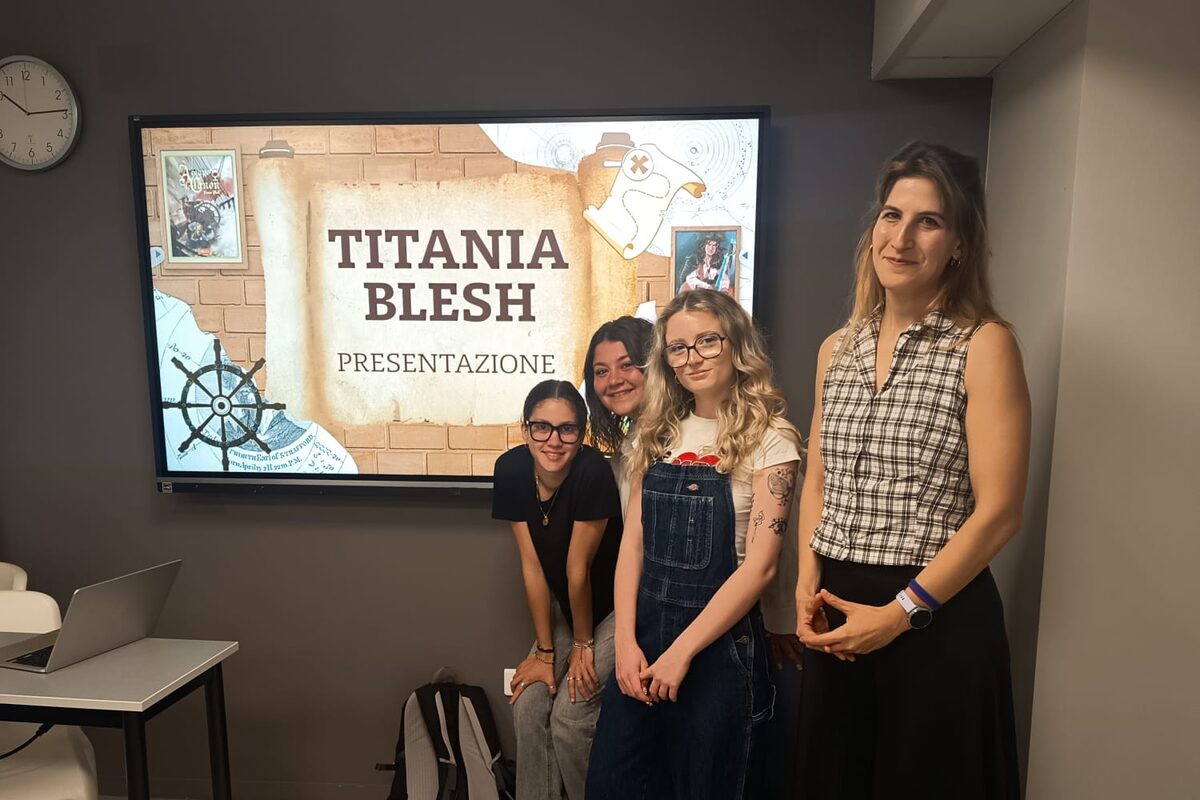 Titania Blesh with the ISCOM students in front of the opening slide of their presentation, which reads Titania Blesh – Presentazione